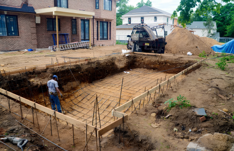 Excavated Blue Haven pool site with steel rebar framework before gunite application