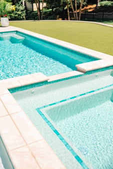 Blue Haven gunite pool shallow ledge with tile border and stone coping