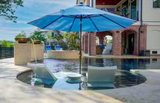 chaise-lounges-and-market-umbrella-on-custom-pool