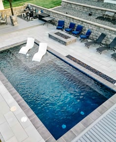 rectangular pool with dark interior finish creating deep blue water color