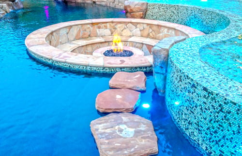 Natural stone floating steps across a tropical resort-style swimming pool