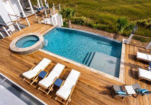 Overhead view of a geometric pool and round spa on a wood deck funded by a pool loan