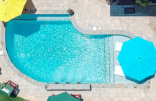 geometric-pool-with-tanning-ledge-umbrellas