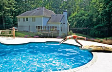 girl-diving-from-jump-rock-into-pool