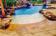 rock-lined-beach-entry-tocustom-pool