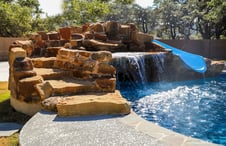 stairs-to-slide-on-rock-waterfall-on-gunite-pool