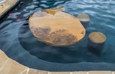 stone-table-and-stools-in-swimming-pool