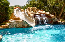 stone-waterfall-grotto-slide-on-swimming-pool