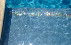 iridescent-glass-tile-on-pool-tanning-ledge