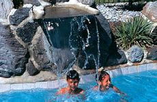 kids-in-pool-below-waterfall