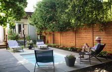 man-relaxing-in-backyard-by-slat-fence