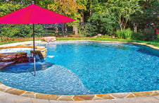 pool tanning ledge with red umbrella