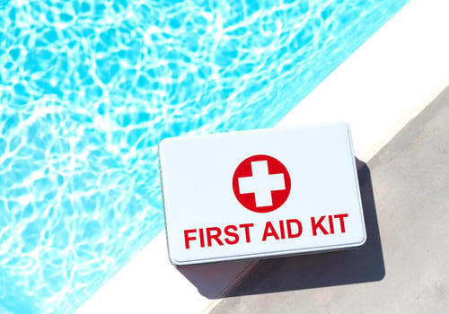 First aid kit sitting on a pool deck next to the water