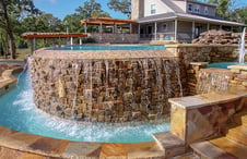 pool-water-flowing-over-stone-infinity-wall-into-catch-basin