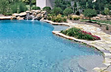 pool-with-rough-cut-stone-deck-and-waterfall