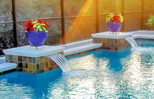 potted-flowers-atop-pedestals-on-inground-pool