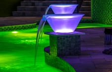 purple-lit-transluscent-water-bowls-on-green-lit-pool