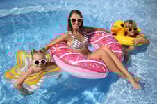mom with son daughter in floating tubes in pool
