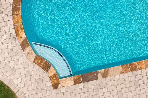 Aerial view of a tanning ledge with mosaic tile accent in a Blue Haven inground pool