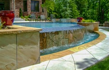 water-ovrflowing-stone-clad-pool-wall-into-basin