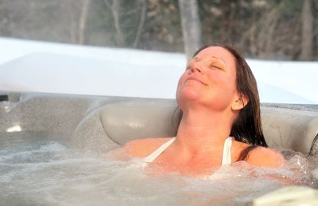 woman relaxing in hot tub during winter